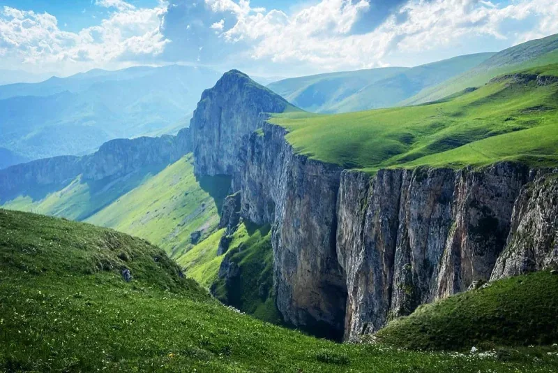 Դիմաց լեռան ուղղահայաց կրաքարային ժայռերն ու կանաչ ալպյան մարգագետինները