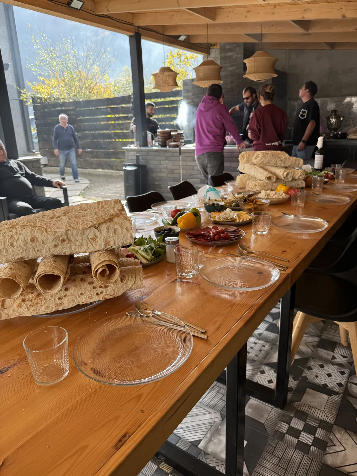 Guests gathered in the gazebo around a long table with lavash and dishes