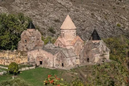 Գոշավանքի եկեղեցիները կոնաձև գմբեթներով՝ ժայռոտ լանջի ստորոտին, աշնանային ծառերի մեջ