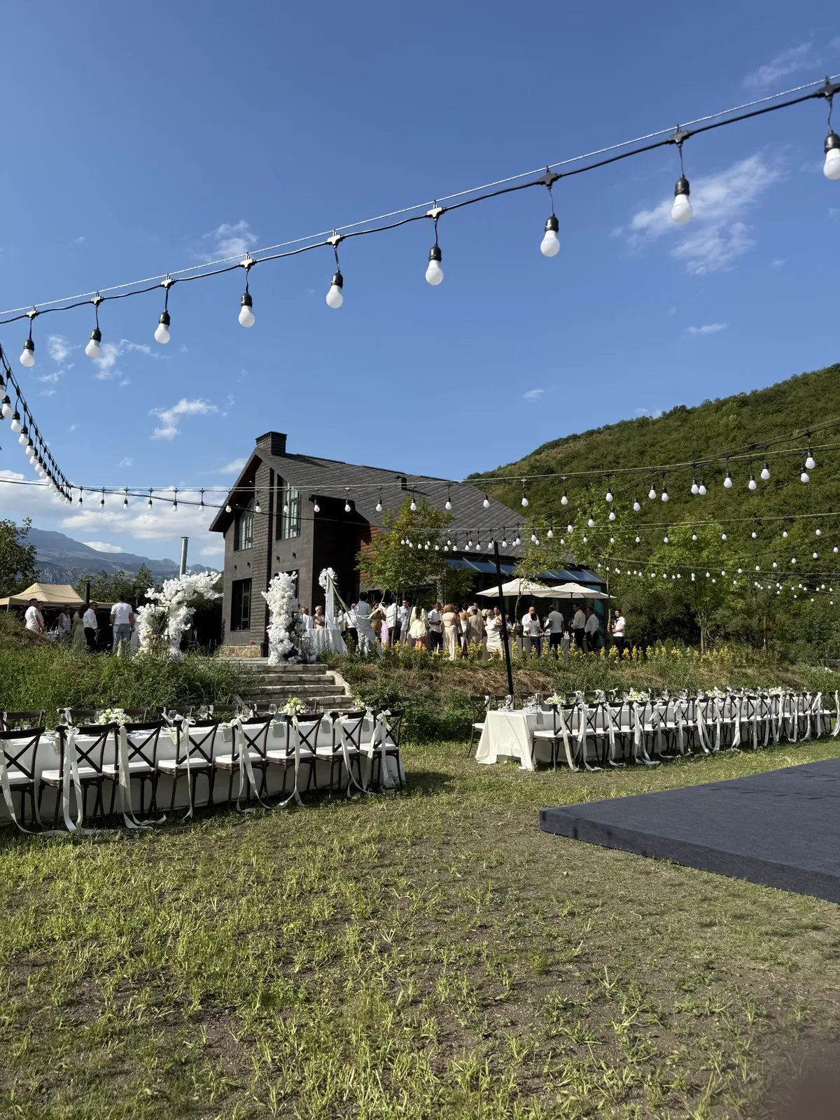 Outdoor wedding on the Black Inn lawn, with long tables and string lights
